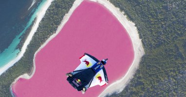 Un survol en wingsuit spectaculaire au dessus d'un lac rose